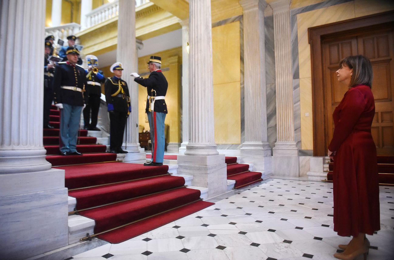 Εικόνα που δείχνει την πρόεδρο της Δημοκρατίας να ακούει τα κάλαντα από την μπάντα του Πολεμικού Ναυτικού