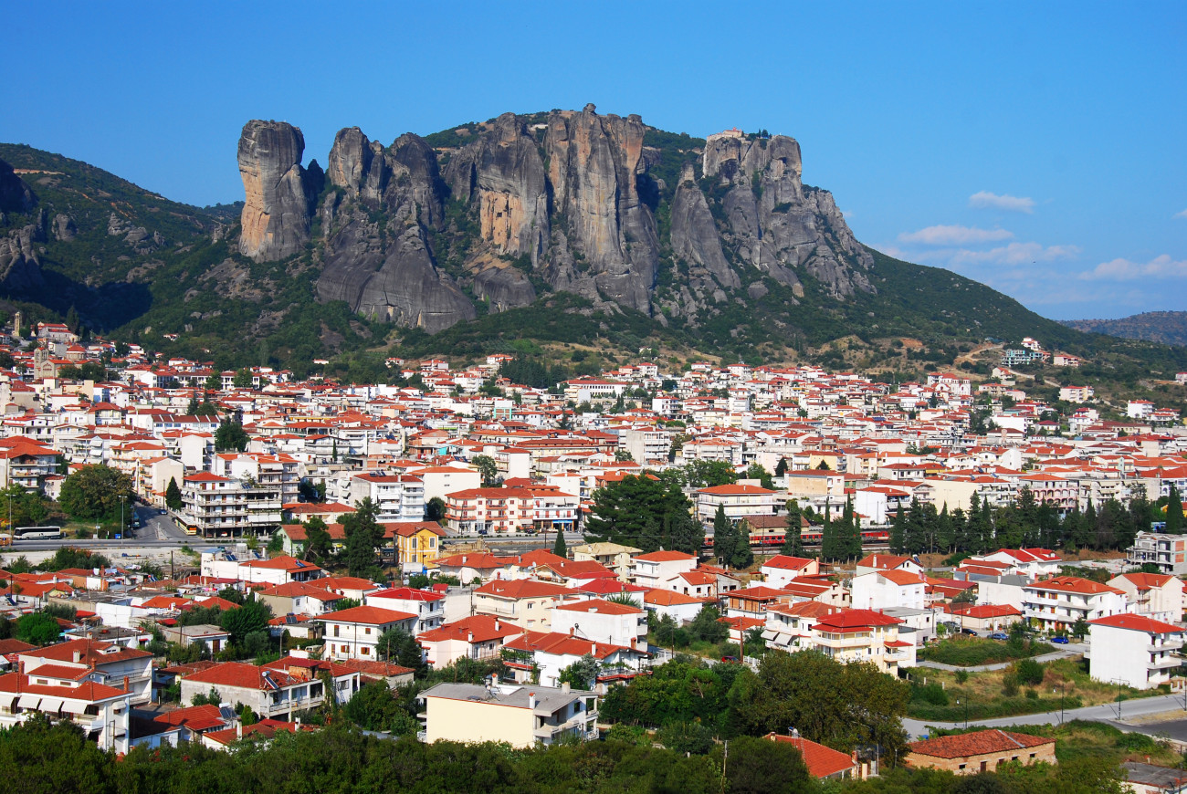 Εικόνα που δείχνει την Καλαμπάκα από ψηλά με φόντο τους επιβλητικούς βράχους των Μετεώρων 